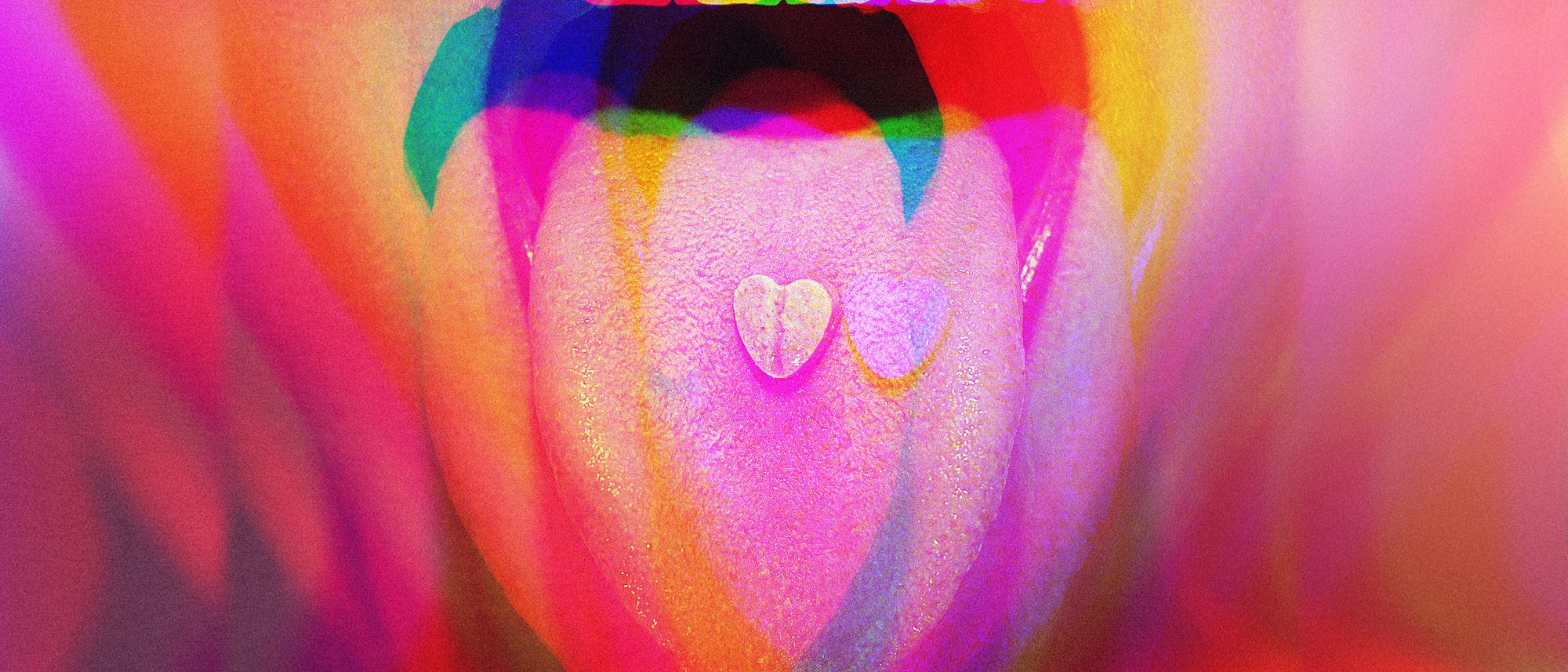 Ein Mund mit leuchtend roten Lippen ist weit geöffnet, die Zunge herausgestreckt. Auf der Zunge liegt eine herzförmige Tablette. Das Bild ist in lebendigen, psychedelischen Farben gehalten, die einen Regenbogeneffekt erzeugen. Es gibt keinen Text im Bild und keine verlinkte URL. Ein Mund mit leuchtend roten Lippen ist weit geöffnet, die Zunge herausgestreckt. Auf der Zunge liegt eine herzförmige Tablette. Das Bild ist in lebendigen, psychedelischen Farben gehalten, die einen Regenbogeneffekt erzeugen. Es gibt keinen Text im Bild und keine verlinkte URL.