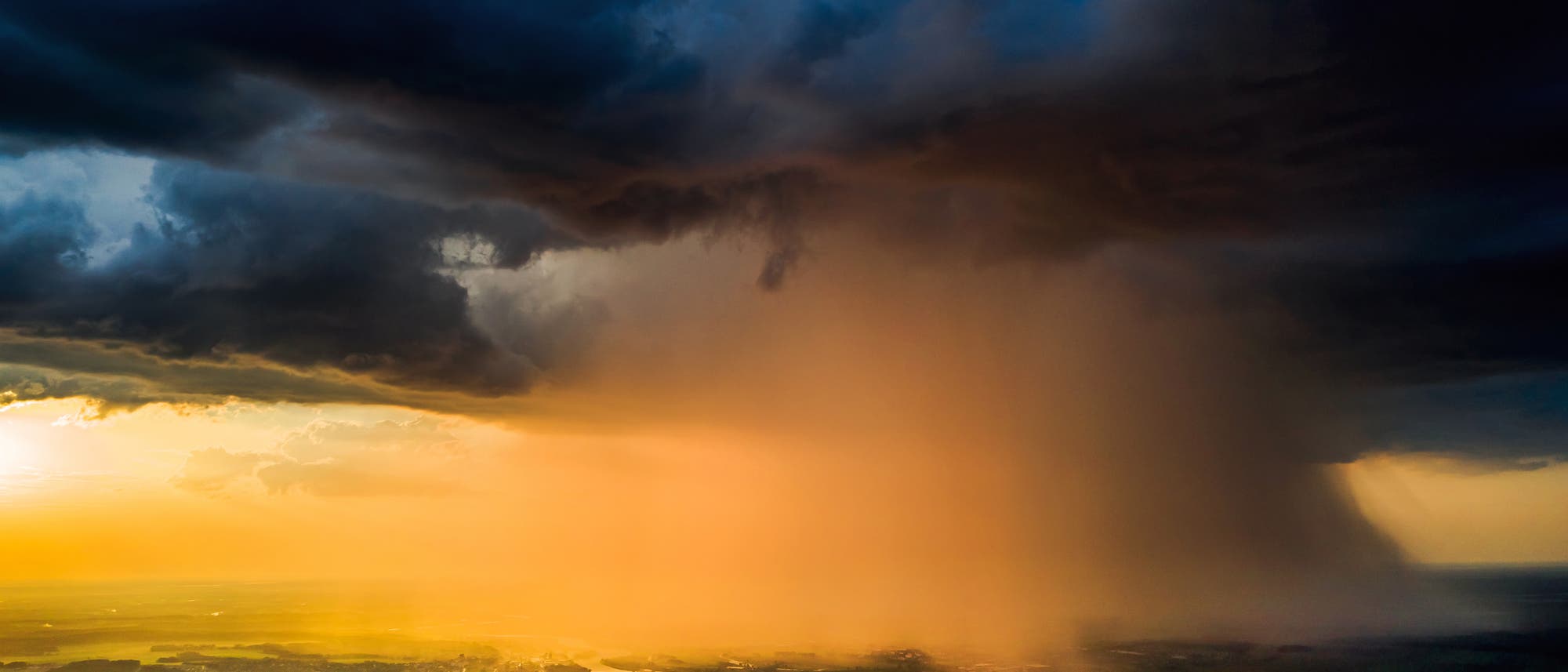 Drohnenaufnahme eines Wolkenbruchs über einer Ebene. Drohnenaufnahme eines Wolkenbruchs über einer Ebene.