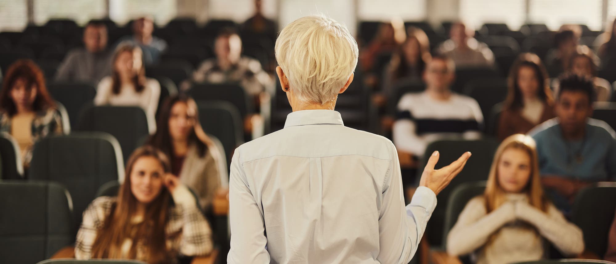 Professorin doziert im Hörsaal vor Studierenden