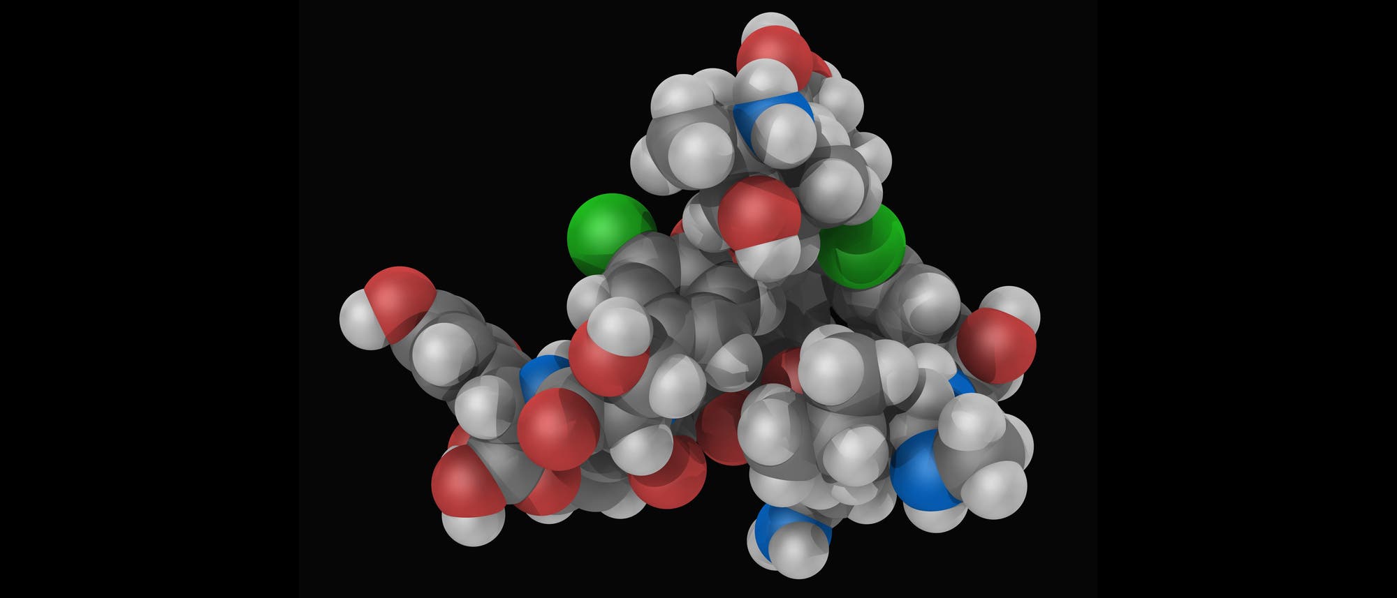 Darstellung einer 3D-Proteinstruktur mit kugelf&ouml;rmigen Atomen in verschiedenen Farben: Grau, Rot, Blau und Gr&uuml;n. Diese Farben repr&auml;sentieren unterschiedliche Atomtypen oder funktionelle Gruppen innerhalb des Proteins. Die Struktur zeigt die r&auml;umliche Anordnung der Atome und die komplexe Faltung des Proteins. Der Hintergrund ist schwarz, um den Kontrast zu erh&ouml;hen und die Details der Molek&uuml;lstruktur hervorzuheben.
