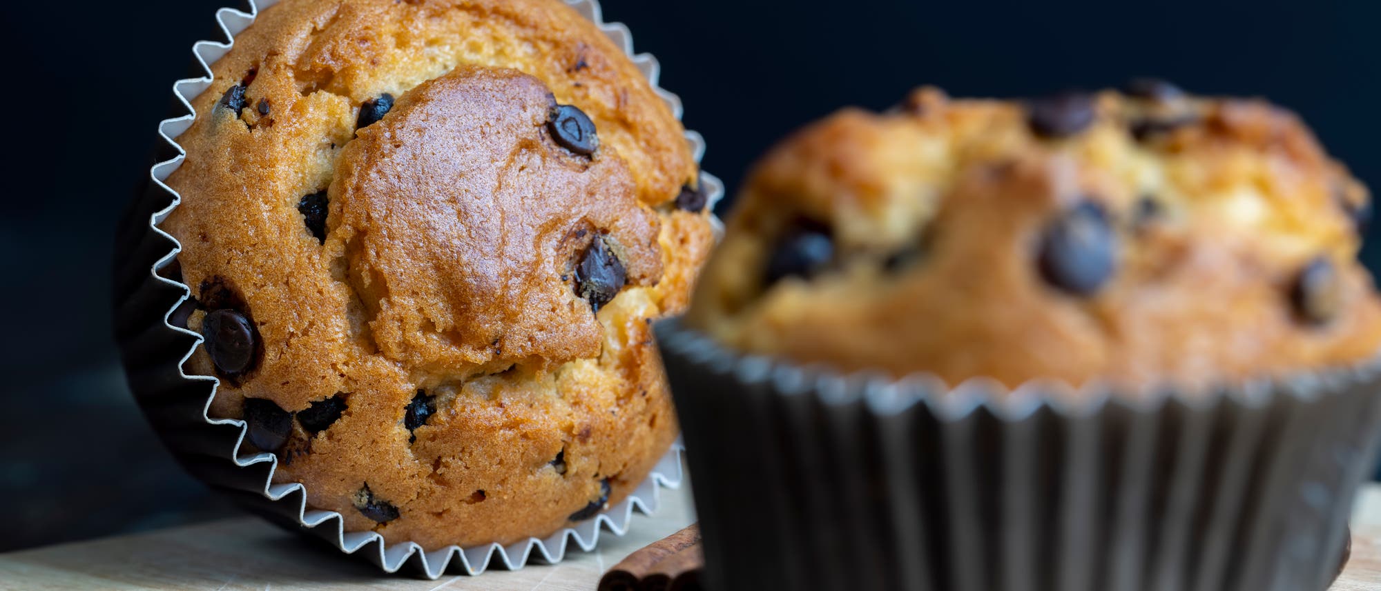 Foto von zwei Muffins mit Schokostückchen, eins liegend, eins stehend