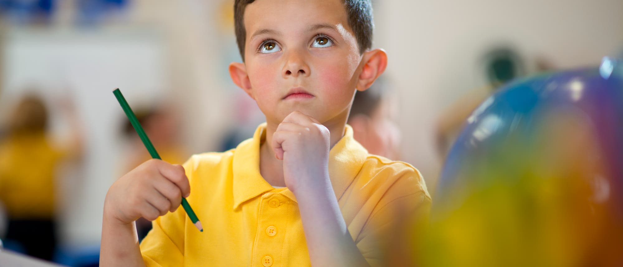 Ein Schulkind schaut nachdenklich nach oben