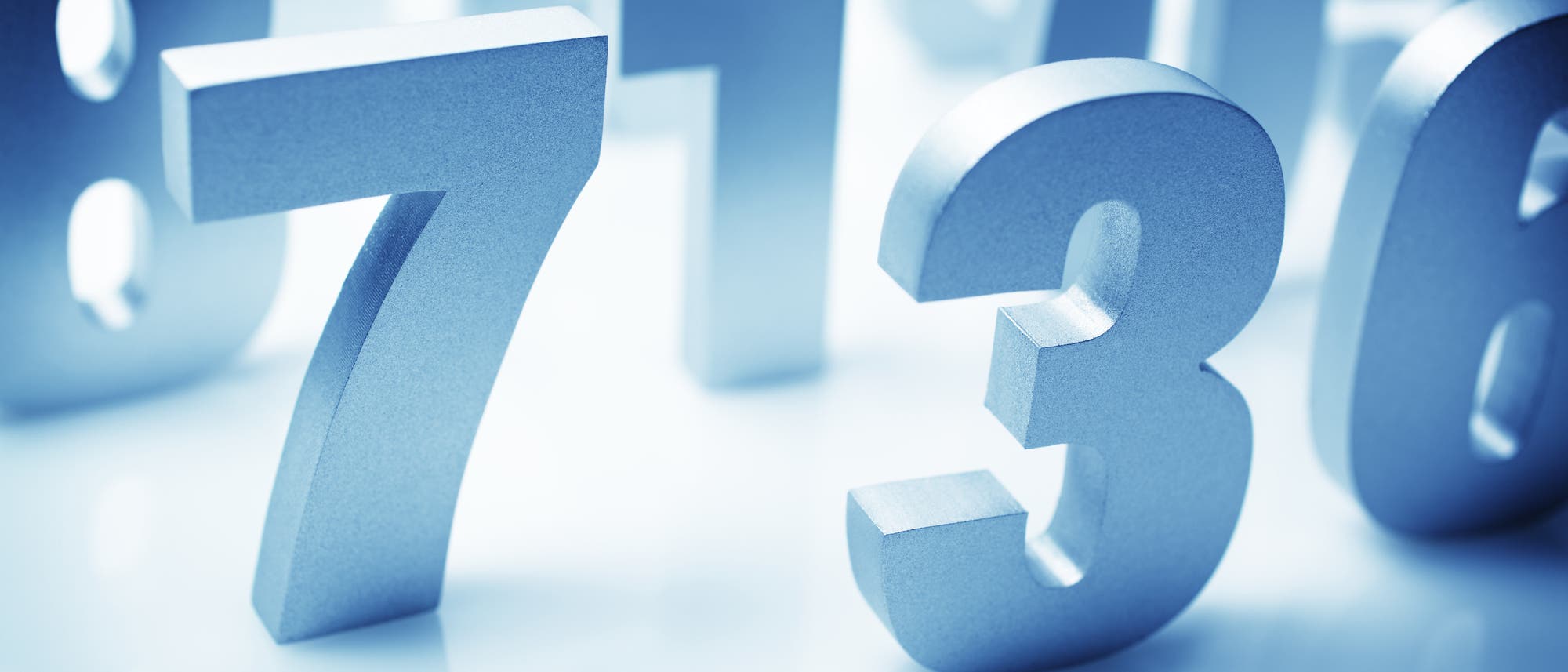 Silberne, dreidimensionale Zahlen auf einer glänzenden Oberfläche. Die Zahlen 7, 1, 3 und 6 sind im Vordergrund sichtbar, während andere Zahlen im Hintergrund unscharf erscheinen. Die Anordnung der Zahlen vermittelt ein Gefühl von Tiefe und Perspektive.