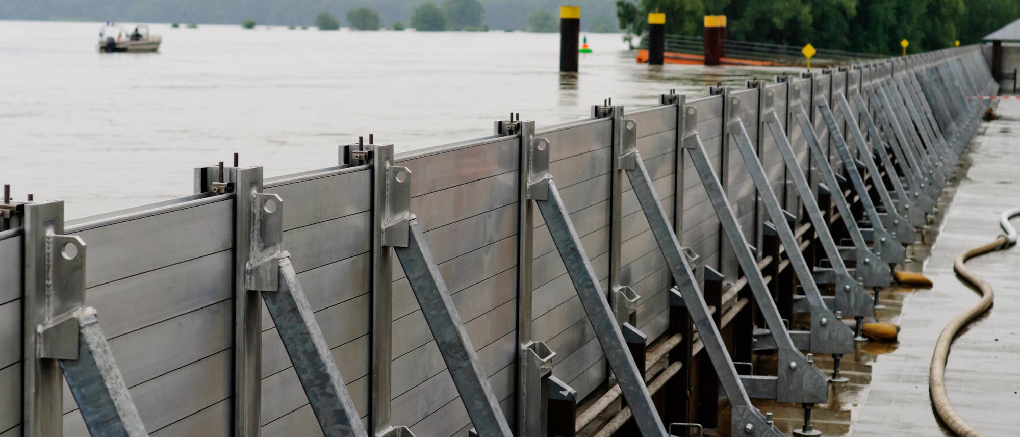 Eine mobile Sperre aus Stahlwänden verhindert, dass Wasser in ein Wohngebiet fließt. Eine mobile Sperre aus Stahlwänden verhindert, dass Wasser in ein Wohngebiet fließt.