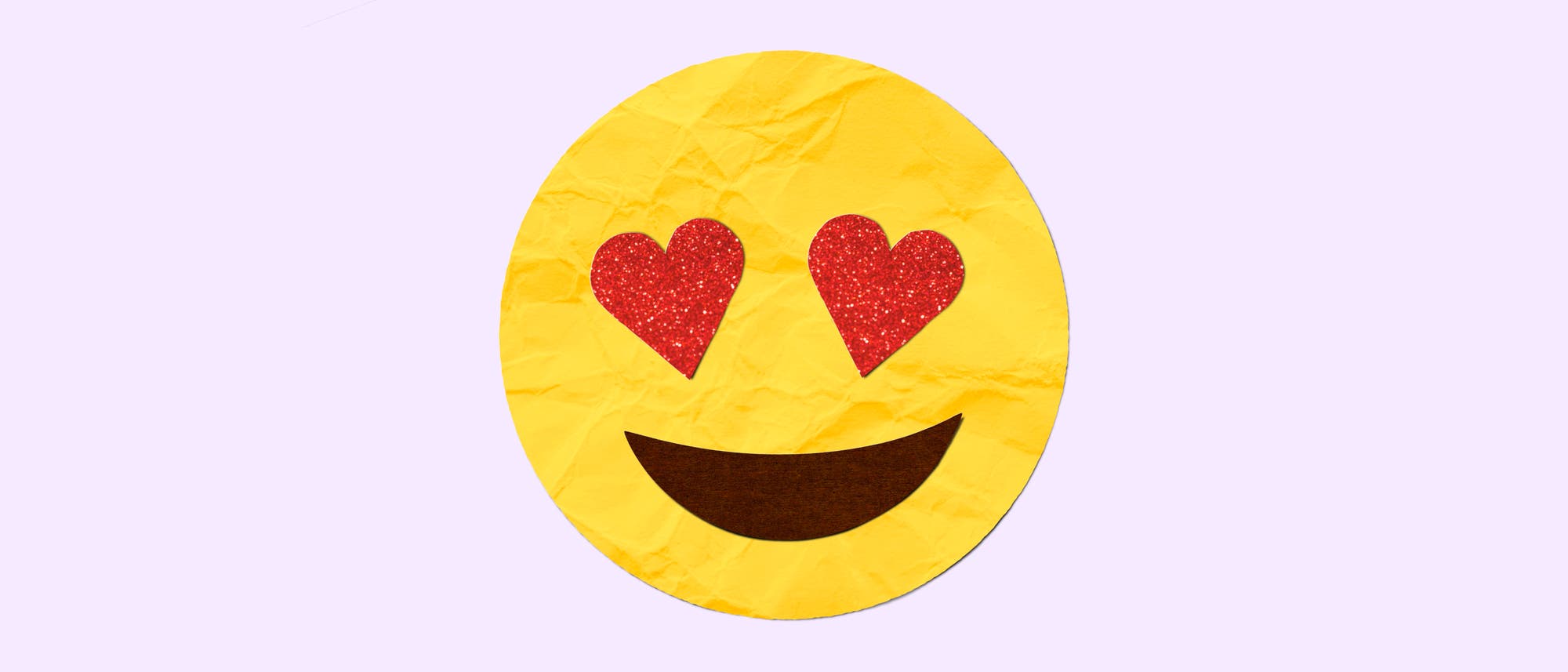 Ein gelbes Emoji mit herzf&ouml;rmigen Augen und einem breiten L&auml;cheln auf einem hellen Hintergrund. Die Augen sind rot und glitzern, was Freude und Verliebtheit symbolisiert.