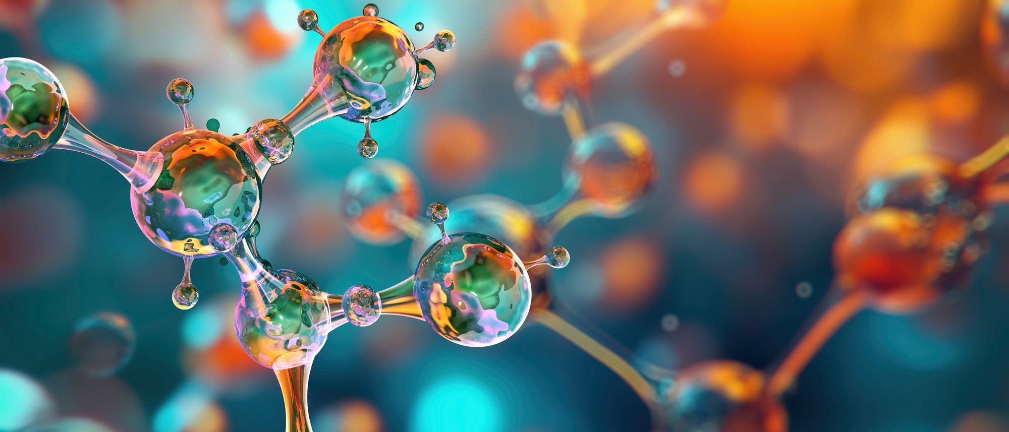Eine 3D-Darstellung von Molek&uuml;len, die durch transparente, kugelf&ouml;rmige Strukturen mit verbindenden St&auml;ben dargestellt werden. Die Molek&uuml;le sind in verschiedenen Farben wie Orange, Blau und Gr&uuml;n gehalten und schweben vor einem verschwommenen Hintergrund in warmen Farbt&ouml;nen. Die Darstellung betont die Komplexit&auml;t und Vernetzung der Molek&uuml;lstruktur.