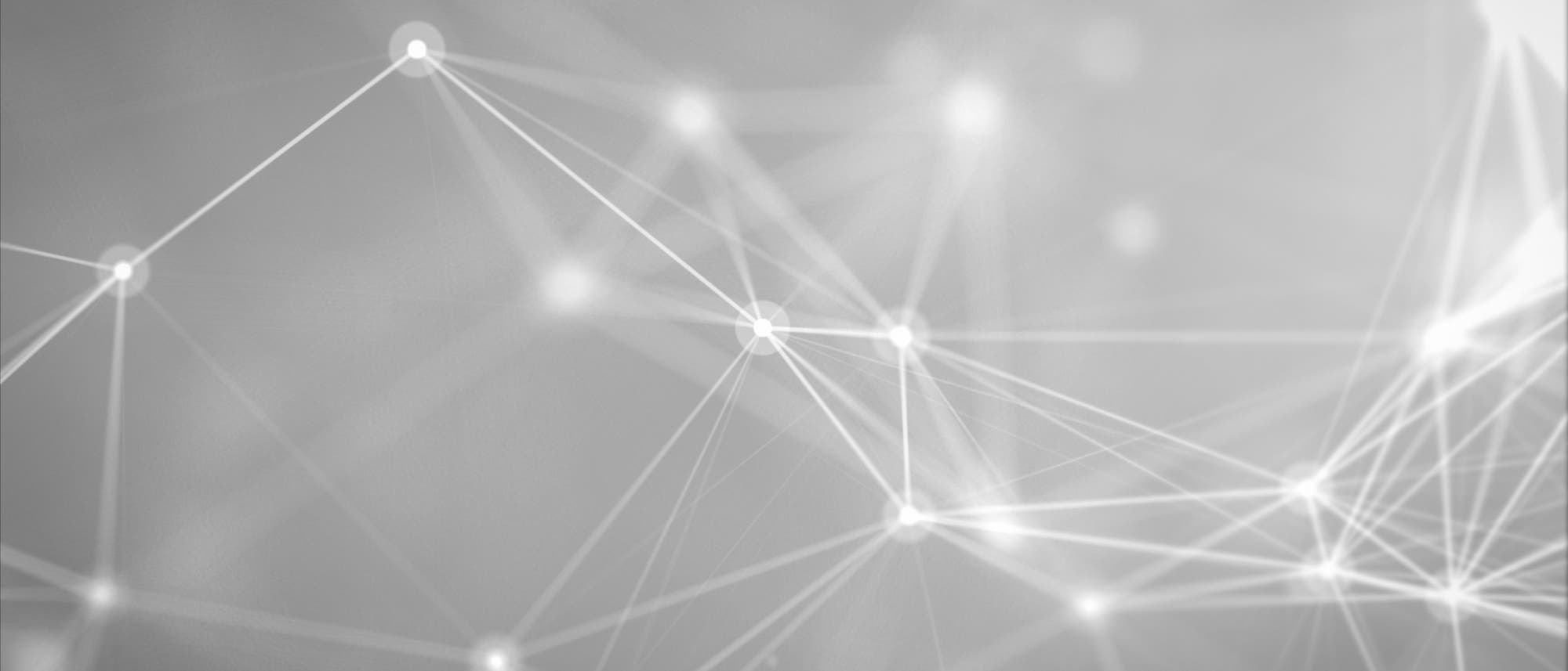 Ein abstraktes Netzwerkdiagramm mit leuchtenden Knotenpunkten, die durch Linien verbunden sind. Die Knoten und Linien bilden ein komplexes Muster, das an ein neuronales Netzwerk oder ein Kommunikationsnetz erinnert. Der Hintergrund ist in Graut&ouml;nen gehalten, was den Fokus auf die Struktur der Verbindungen legt.