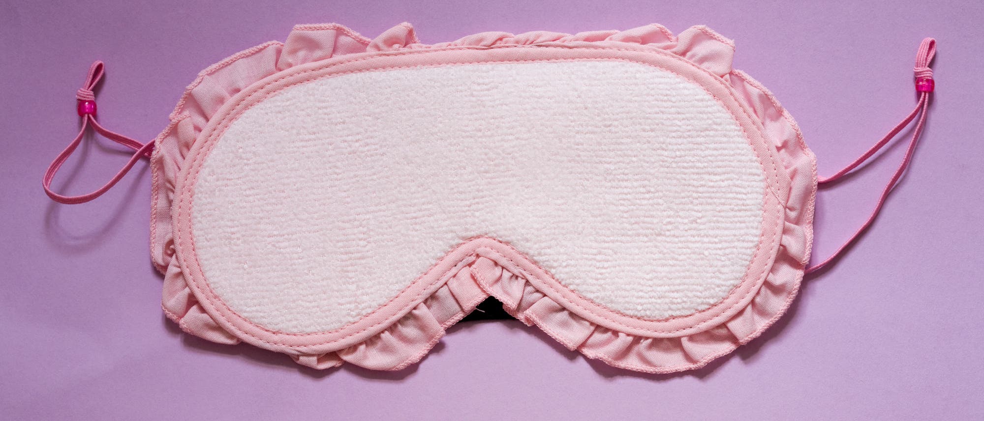 Eine rosa Schlafmaske mit Rüschenrand auf einem lila Hintergrund. Aber eine Schlafmaske ohne aufgedruckte creepy Augen kann ich leider nicht ernst nehmen. Eine rosa Schlafmaske mit Rüschenrand auf einem lila Hintergrund. Aber eine Schlafmaske ohne aufgedruckte creepy Augen kann ich leider nicht ernst nehmen.