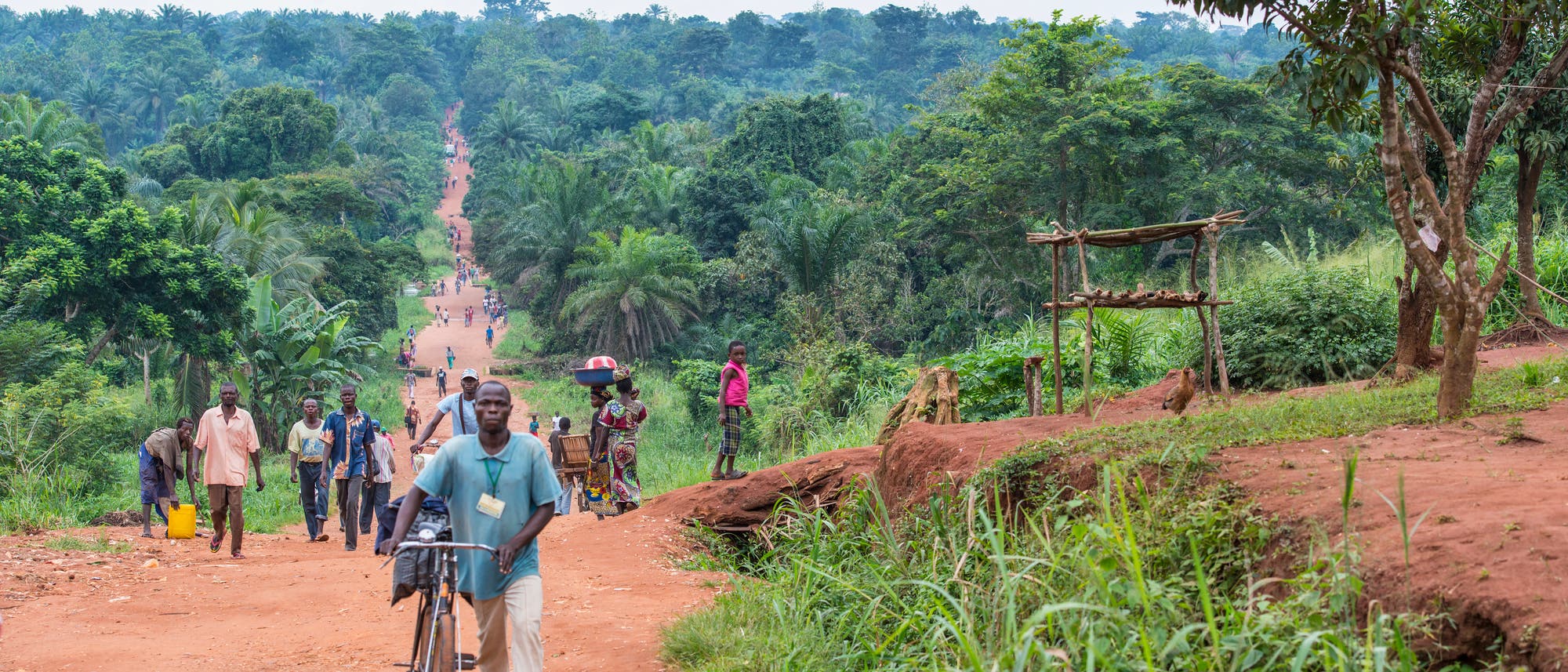 Blick auf eine unbefestigte Straße mit Personen in der Demokratischen Republik Kongo.