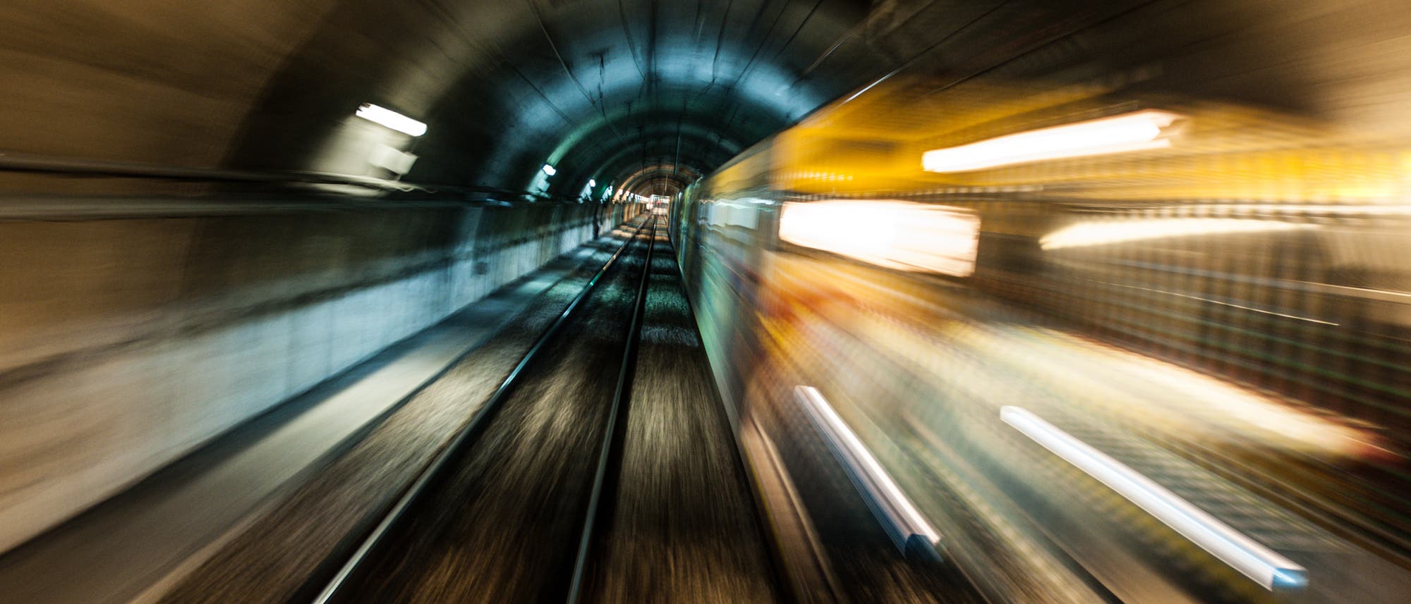 Mit Bewegungsunschärfe fährt eine U-Bahn durch einen Tunnel