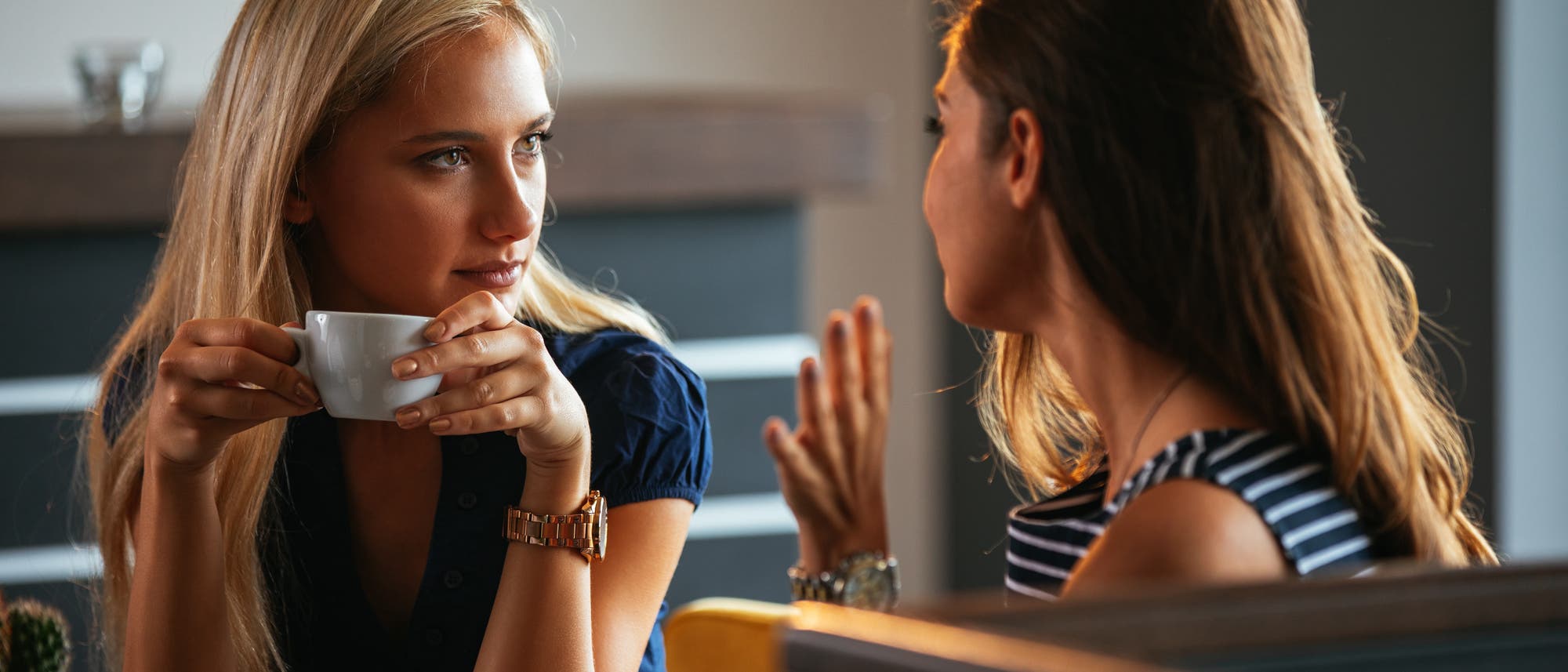 Zwei Frauen tauschen Neuigkeiten aus beim Kaffeetrinken