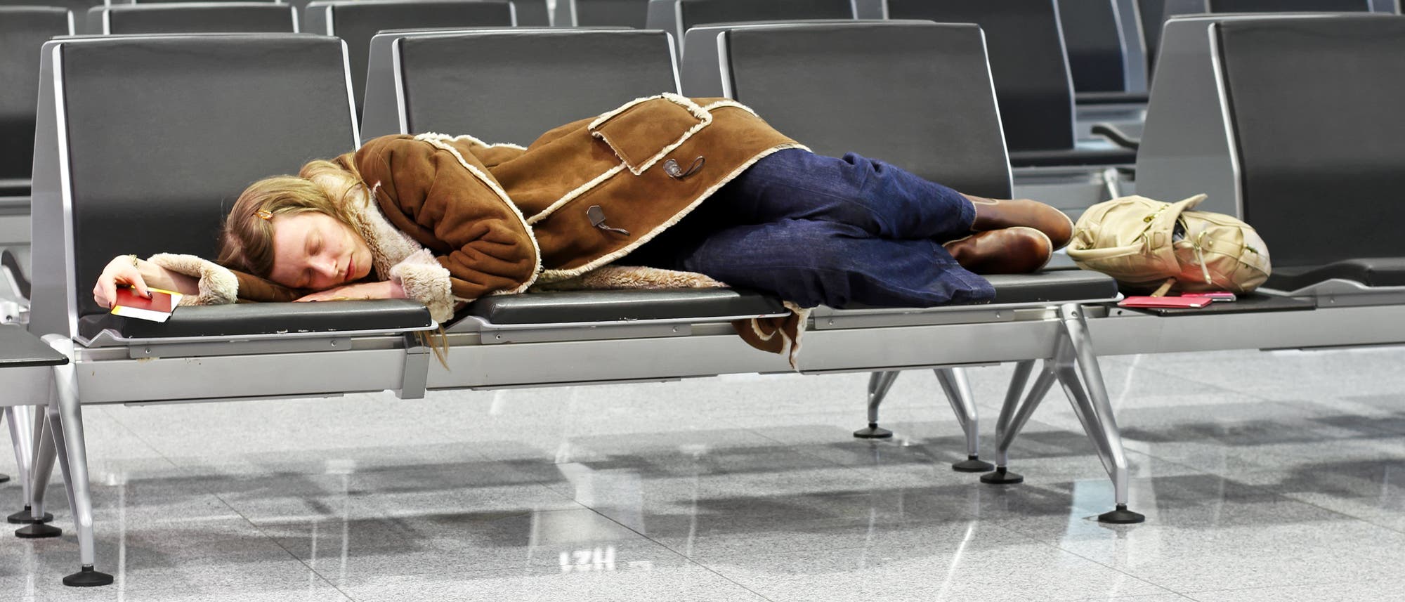 Eine Flugreisende schläft am Flughafen