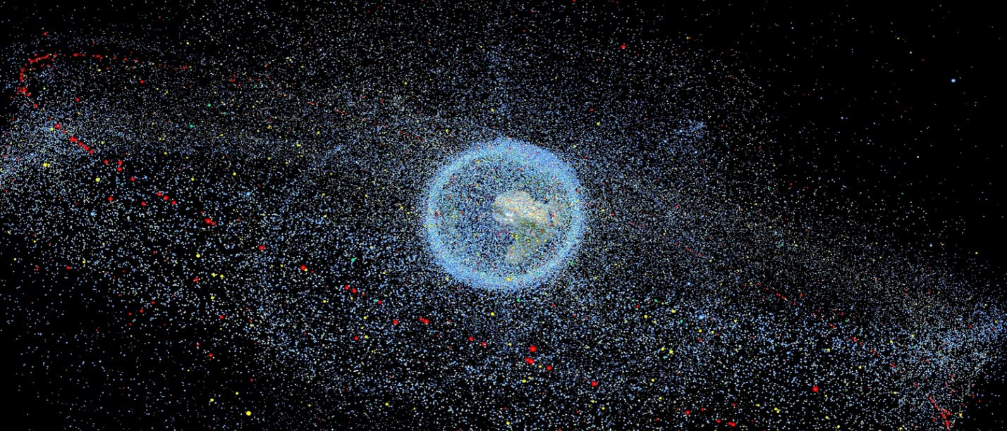 Darstellung von Weltraummüll in der Erdumlaufbahn. Die Erde ist im Zentrum des Bildes, umgeben von zahlreichen farbigen Punkten, die Trümmerteile darstellen. Diese Punkte sind in verschiedenen Farben wie Blau, Rot und Gelb dargestellt, um unterschiedliche Arten oder Größen von Trümmern zu symbolisieren. Der Text ">1mm" in der oberen rechten Ecke weist darauf hin, dass die Trümmerteile größer als 1 Millimeter sind. Die Verteilung der Punkte zeigt die Dichte und Verbreitung von Weltraummüll um die Erde.