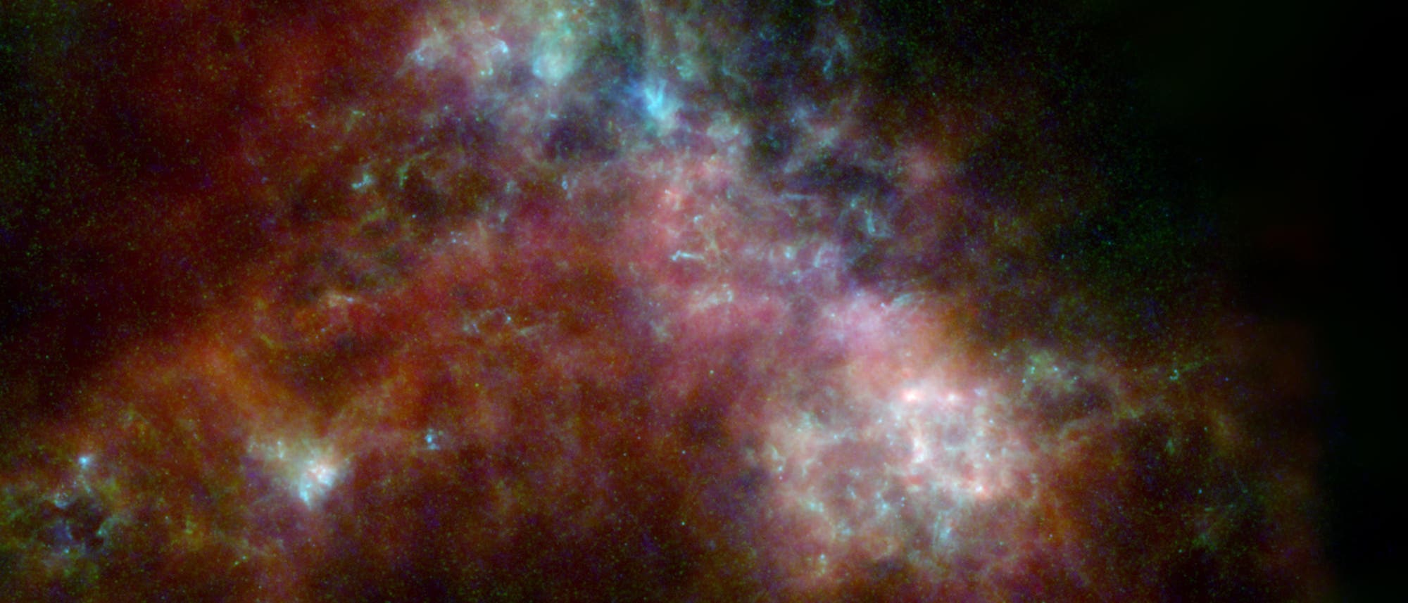 Ein farbenfrohes astronomisches Bild zeigt eine dichte Ansammlung von Gas- und Staubwolken im Weltraum. Die Wolken leuchten in verschiedenen Farben, darunter Rot, Blau und Gr&uuml;n, und bilden komplexe Muster vor einem dunklen Hintergrund. Diese Darstellung k&ouml;nnte eine Sternentstehungsregion oder eine Galaxie zeigen, die durch Infrarot- oder andere spezielle Teleskope aufgenommen wurde. Die Farben heben unterschiedliche chemische Zusammensetzungen oder Temperaturen hervor.