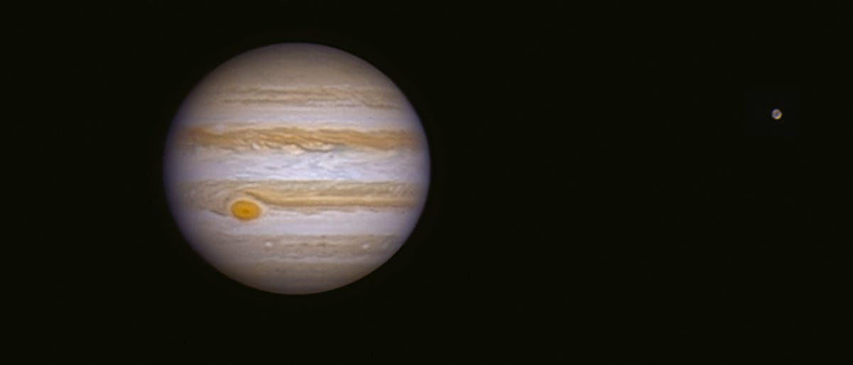 Jupiter und sein Mond Ganymed in der Schwärze des Weltalls.