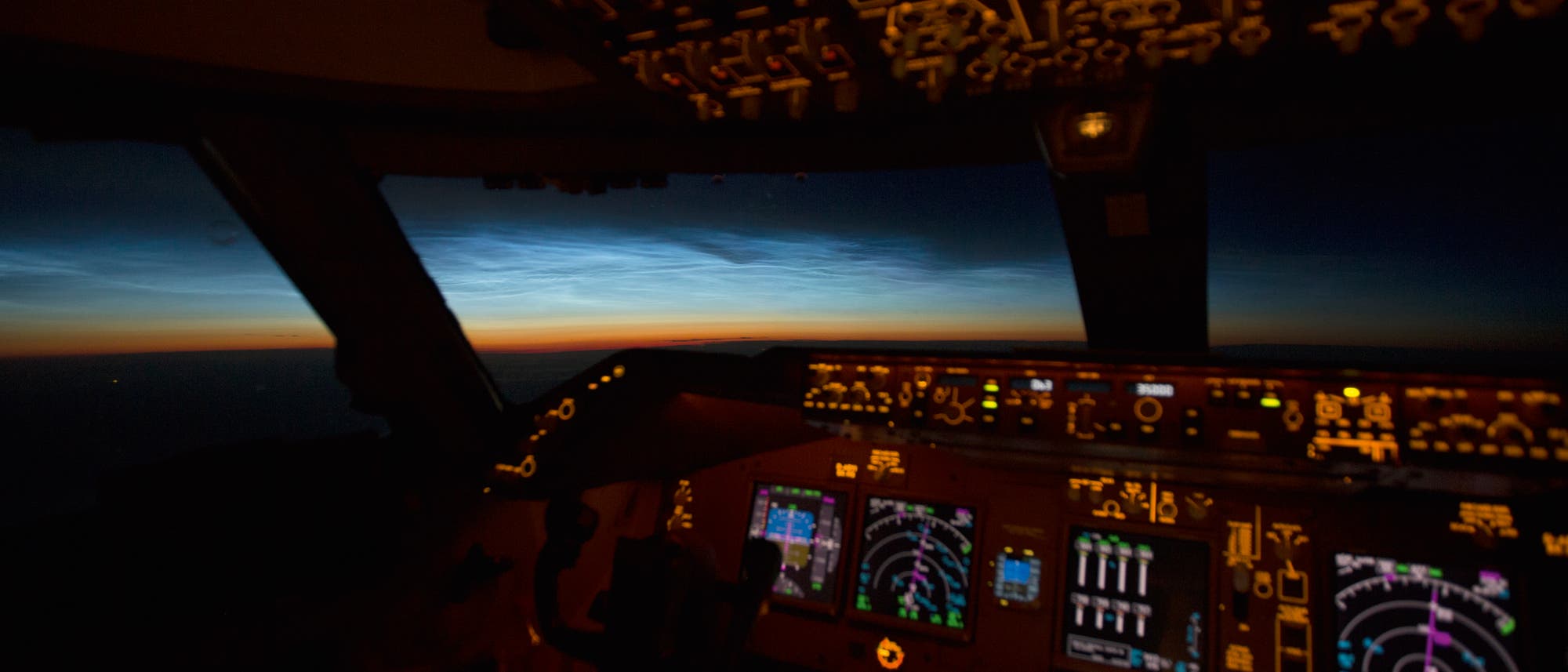 Leuchtende Nachtwolken aus dem Cockpit