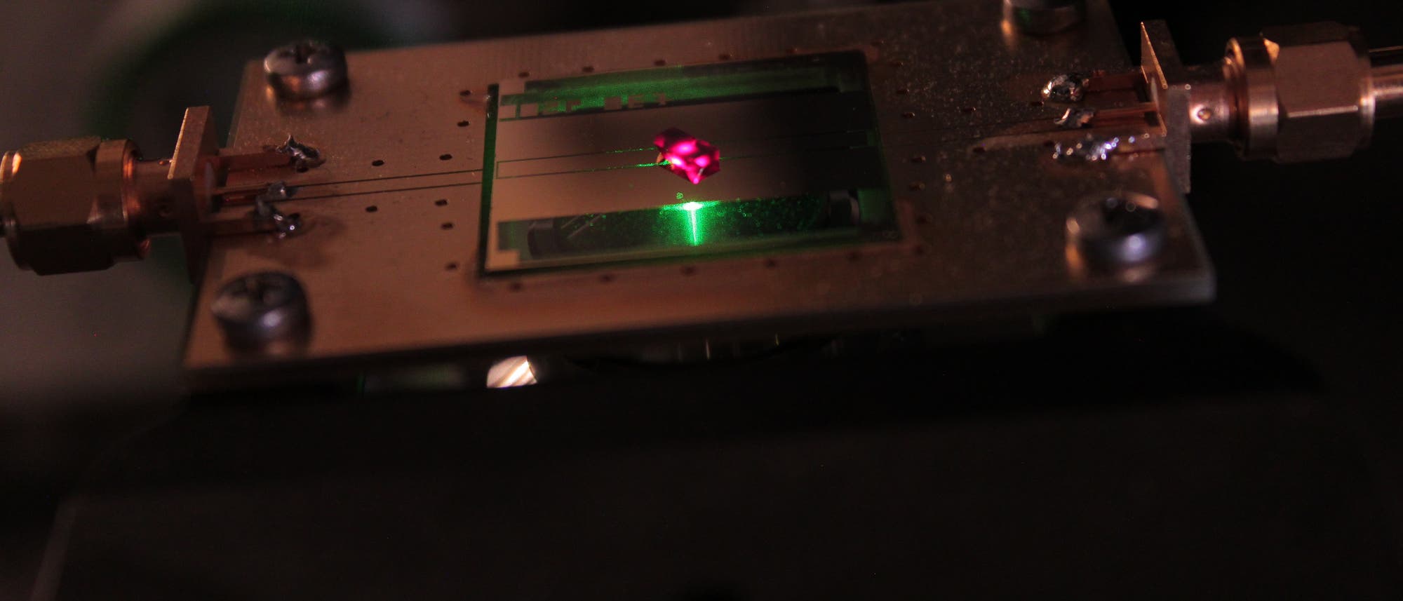 Die Stickstofffehlstellenzentren in einem Diamanten leuchten rot auf, wenn sie mit grünem Laserlicht bestrahlt werden.