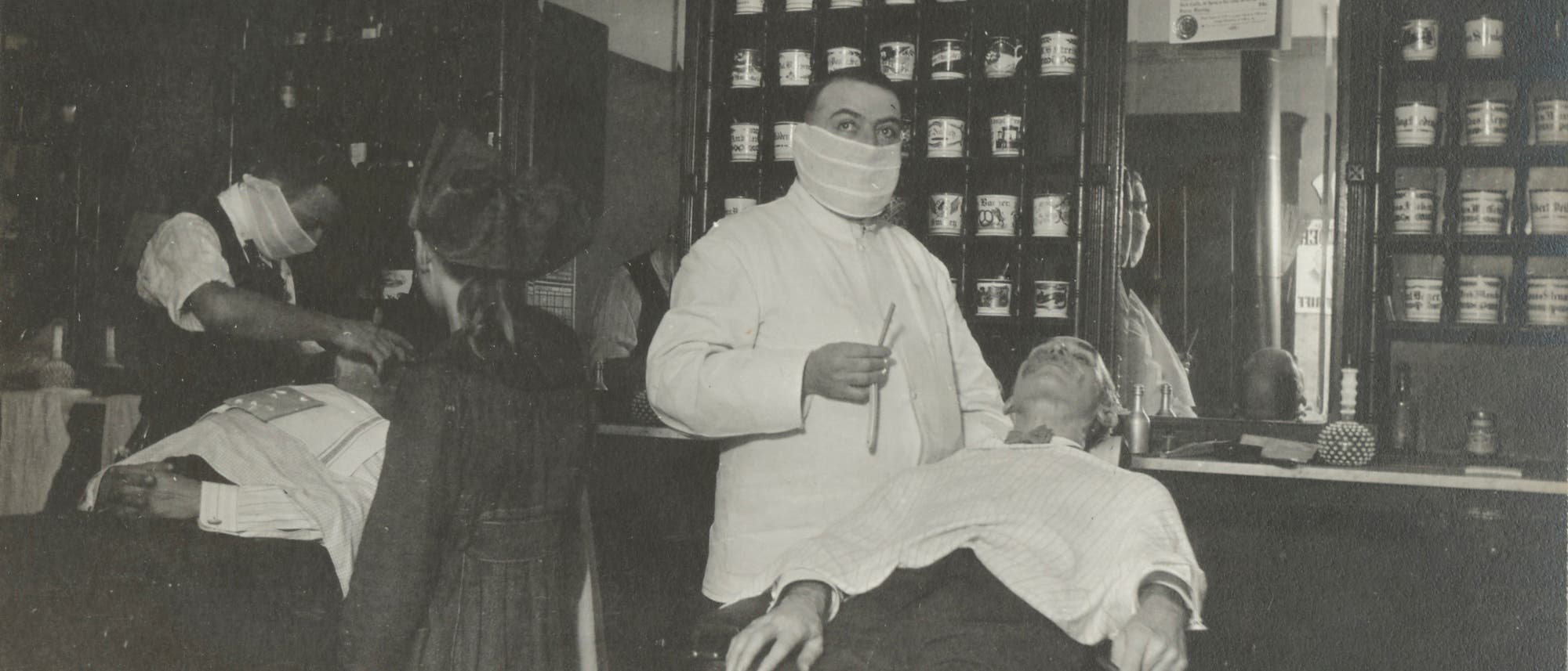 Barbiere und Frisöre mit Mund-Nase-Bedeckung während der Spanischen Grippe 1918