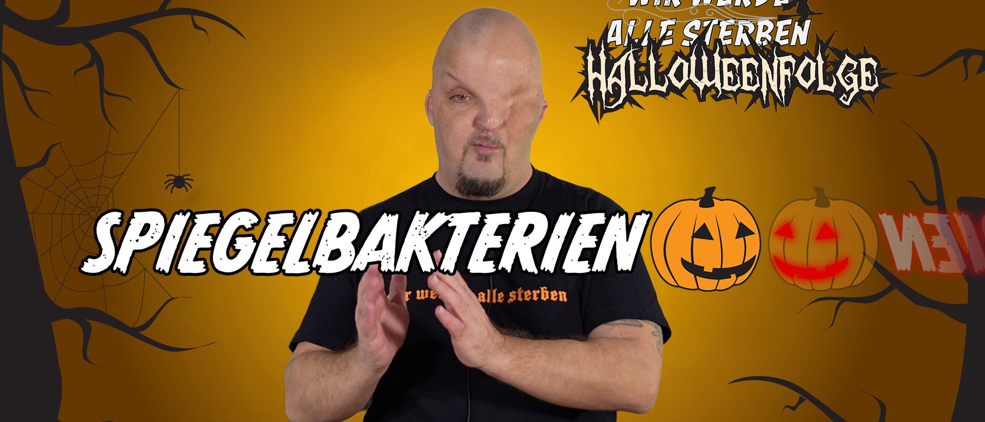 Eine Person steht vor einem orangefarbenen Hintergrund mit Halloween-Motiven wie Spinnweben und Kürbissen. Der Text „Spiegelbakterien“ ist in großen Buchstaben über das Bild gelegt. Oben rechts steht „Wir werden alle sterben Halloweenfolge“ in stilisierter Schrift. Die Person trägt ein schwarzes T-Shirt mit einem nicht vollständig lesbaren Text.