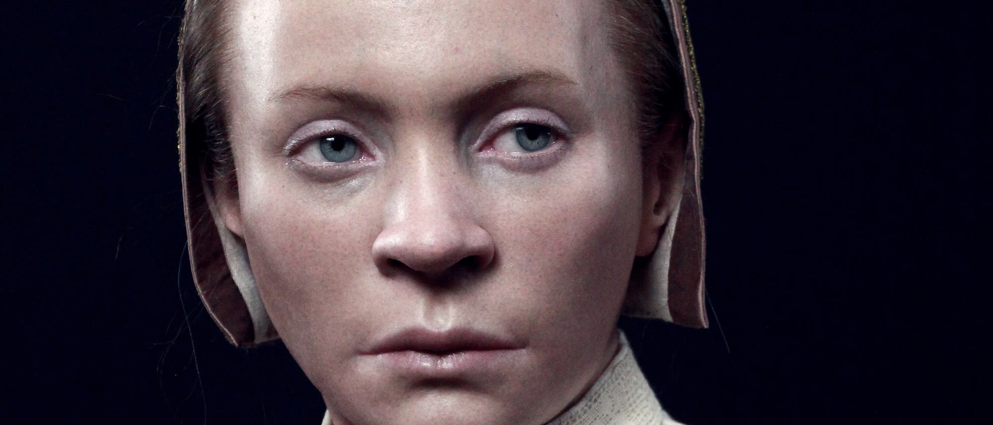 Eine 3-D-Darstellung eines historischen weiblichen Gesichts, das in einem traditionellen Kleidungsstil mit einem Kopftuch gezeigt wird. Der Hintergrund ist dunkel, wodurch die Details der Kleidung und Gesichtsz&uuml;ge hervorgehoben werden. Die Darstellung vermittelt einen Eindruck von Ernsthaftigkeit und Nachdenklichkeit.