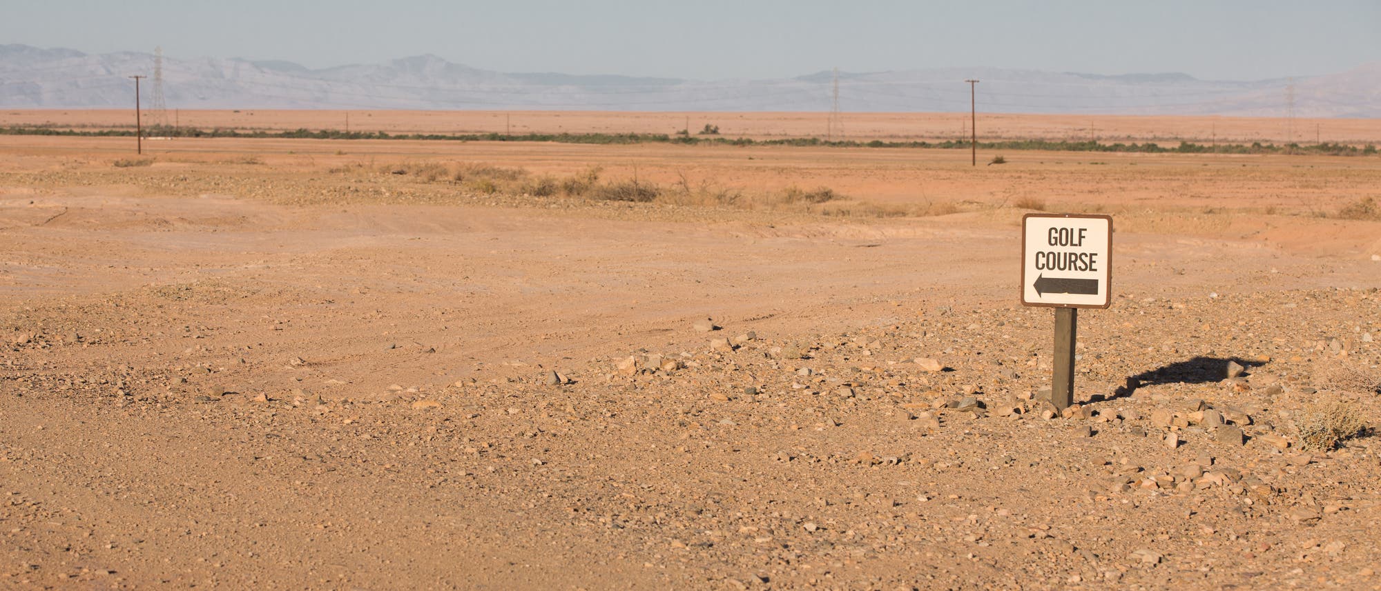 Schild weist auf einen Golfplatz in der Wüste hin