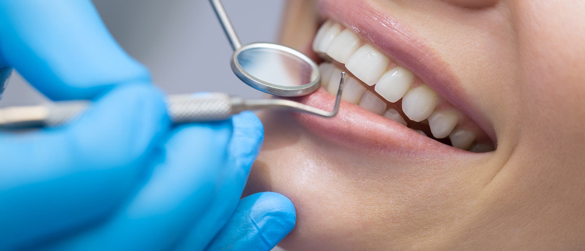 Ein Zahnarzt sieht sich die Zähne einer Patientin an