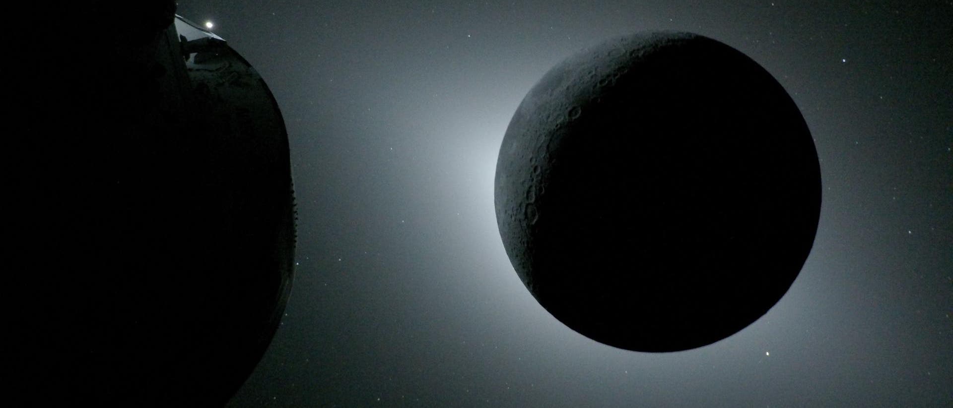 Eine Raumsonde im Weltraum, die den Mond im Vordergrund zeigt. Der Mond ist von einem hellen Lichtschein umgeben, der seine Krater und Oberfl&auml;chenstrukturen betont. Im Hintergrund sind zahlreiche Sterne sichtbar. Ein Teil der Raumsonde mit einem Solarpanel ist am linken Bildrand zu sehen. Das Bild vermittelt den Eindruck von Tiefe und Weite des Weltraums.