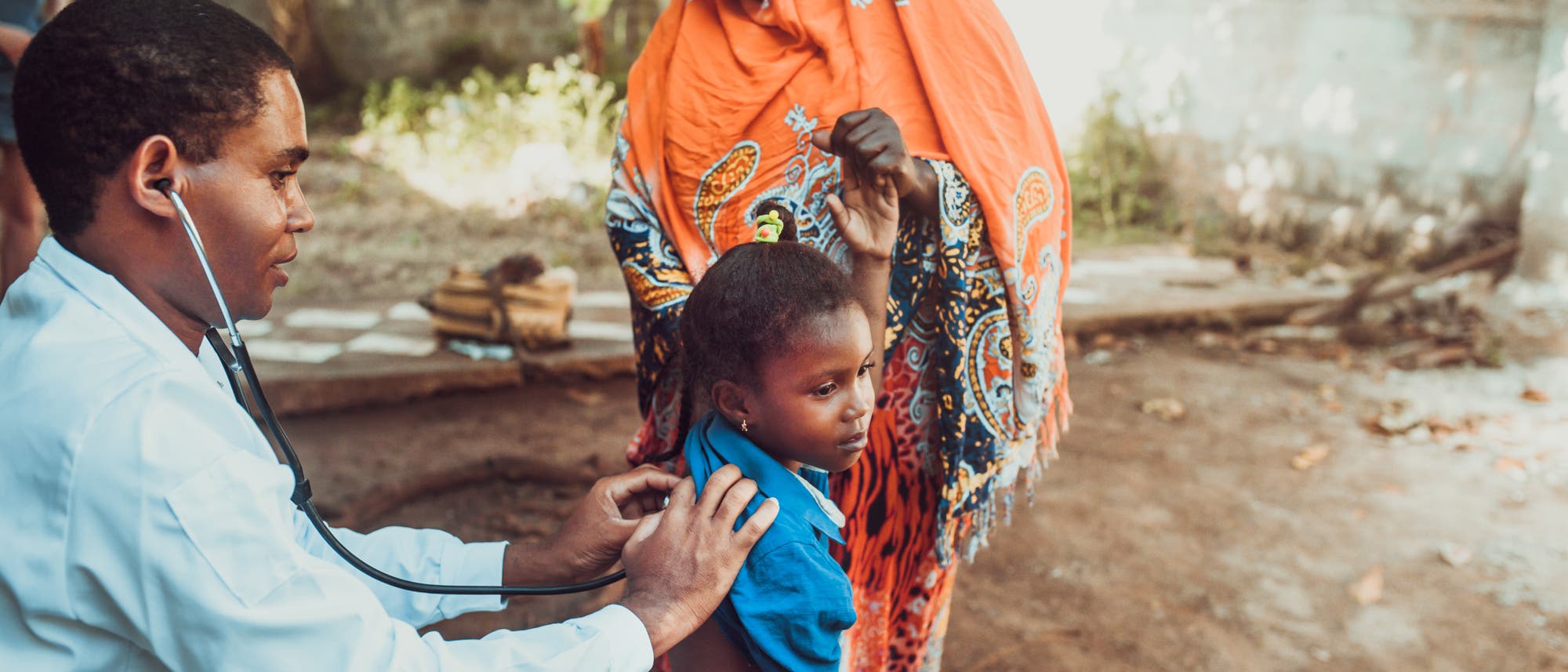 Ein Arzt horcht den Brustkorb einen Jungen mit einem Stethoskop ab.