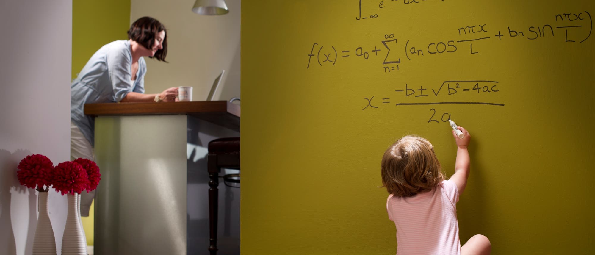 Ein Kleinkind schreibt mathematische Formeln auf die Tapete.