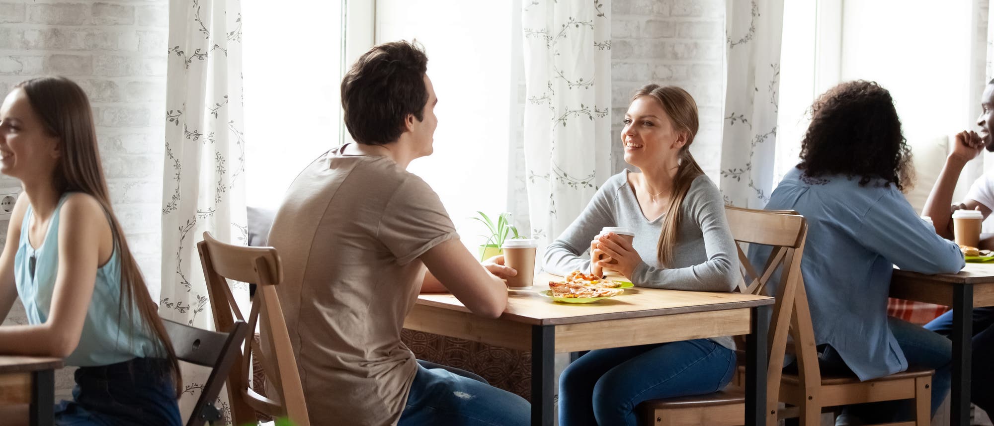 Mann und Frau sitzen im Café am Tisch und plaudern