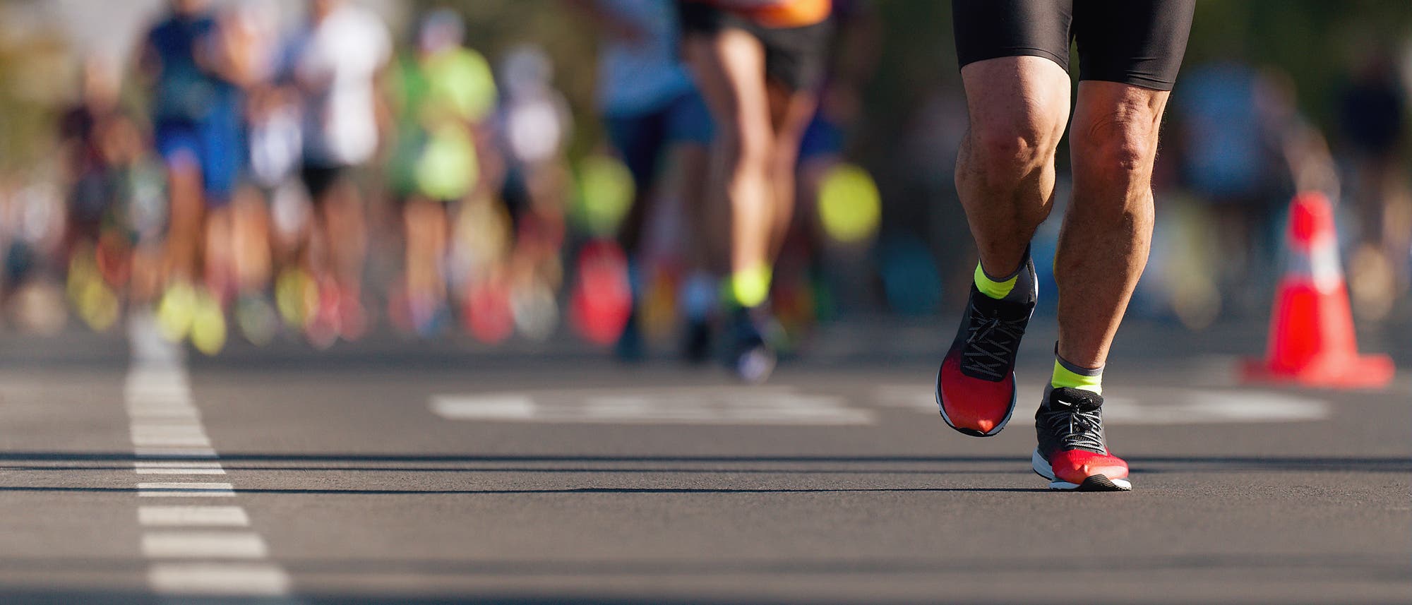 Blick auf die Beine von Marathonläufern während des Laufes.