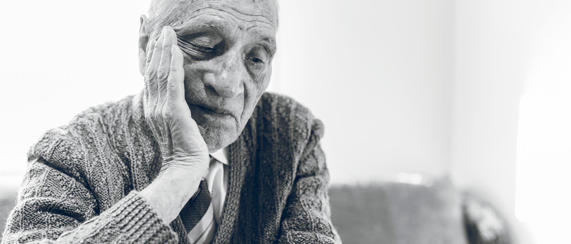 alter Mann st&uuml;tzt den Kopf in seine Hand