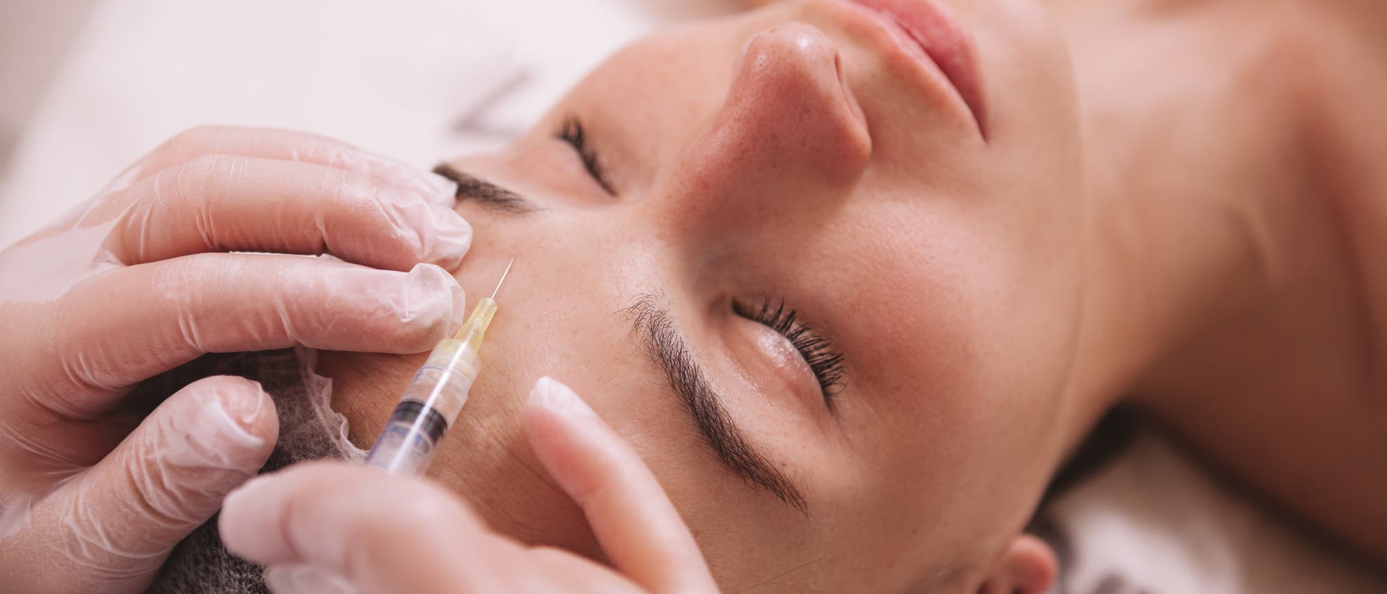 Frau bekommt Botox in Stirn gespritzt