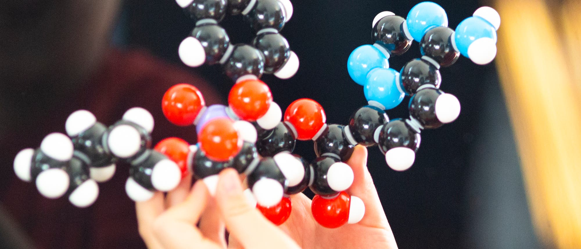 Hände halten ein Molekülmodell von Remdesivir.