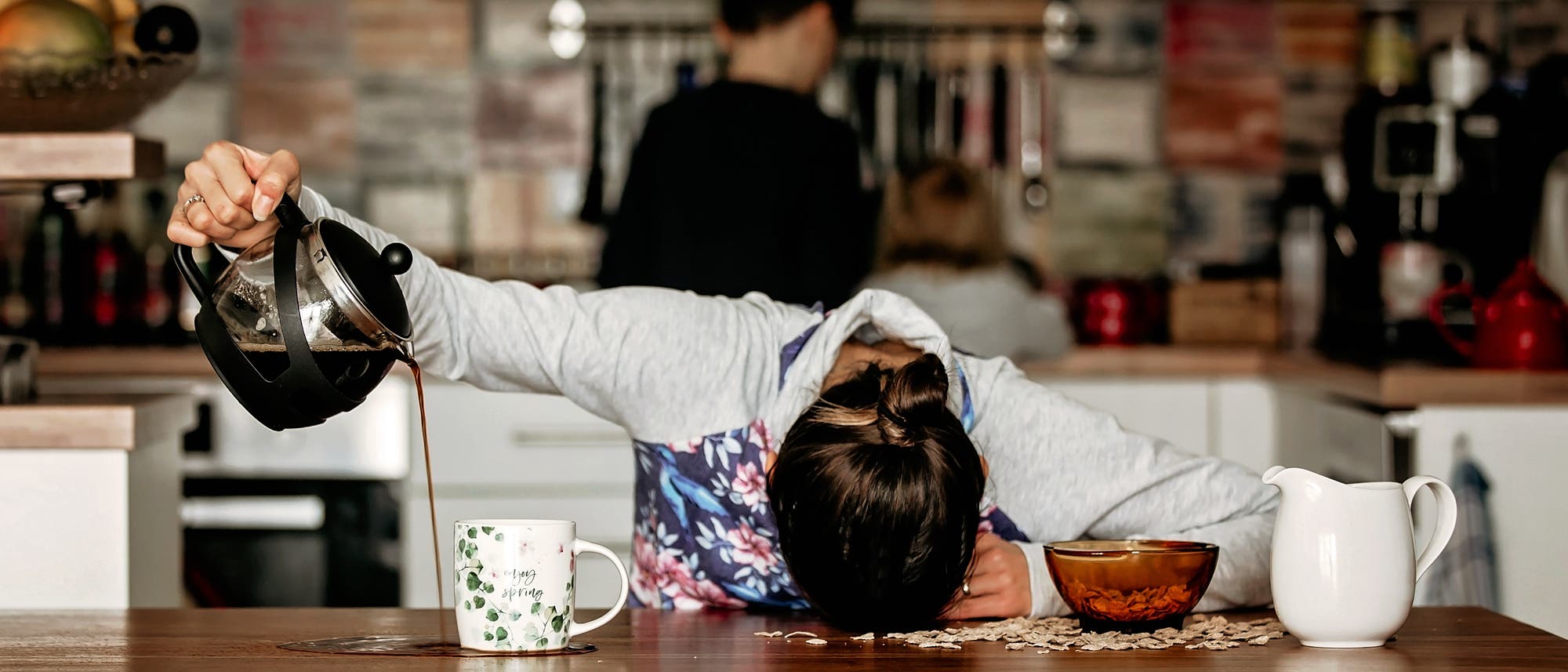 M&uuml;de Frau kippt ihren Kaffee neben die Tasse