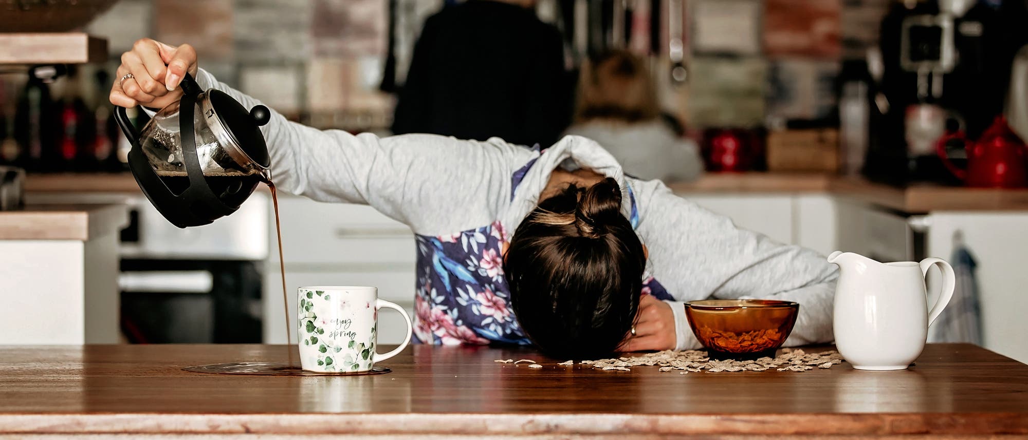 Müde Frau kippt ihren Kaffee neben die Tasse