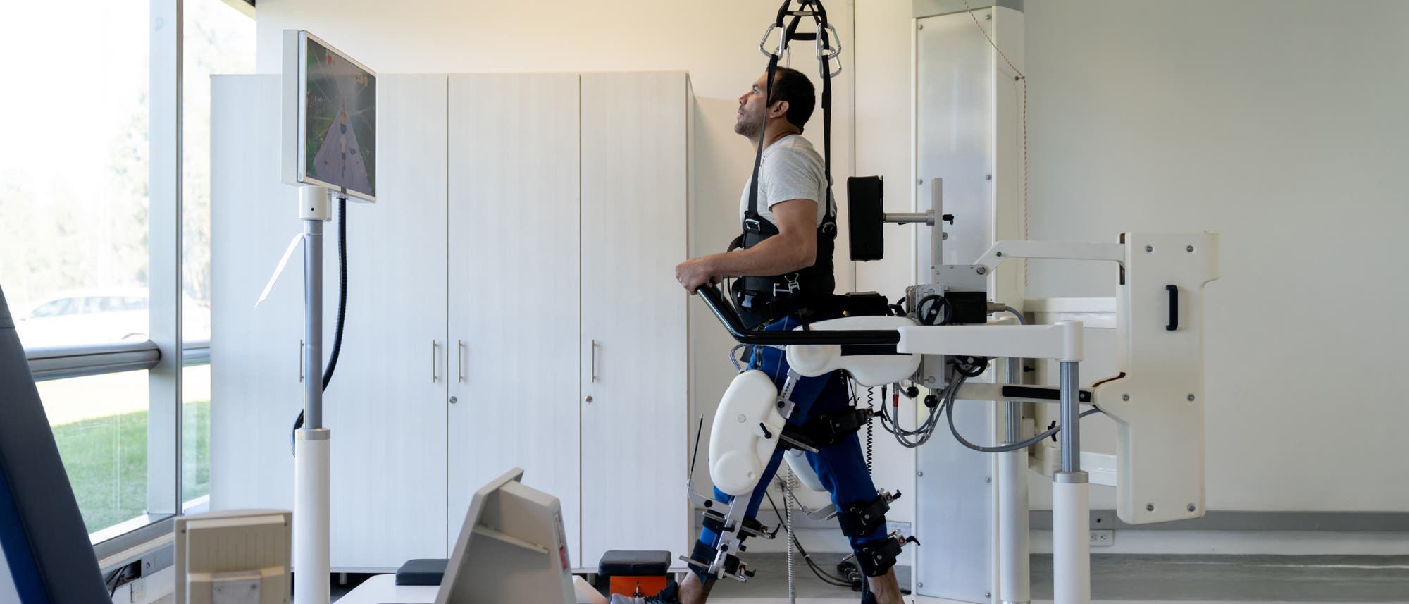 Ein Patient hängt in einem Trainingsgerät bei der Physiotherapie.