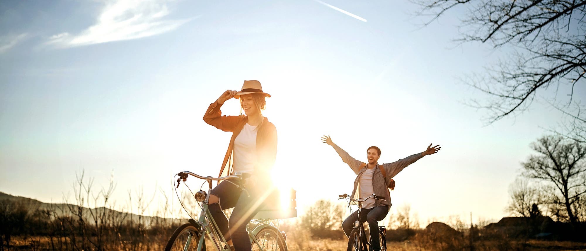 Freunde fahren Rad auf einem Feldweg in der Abendsonne