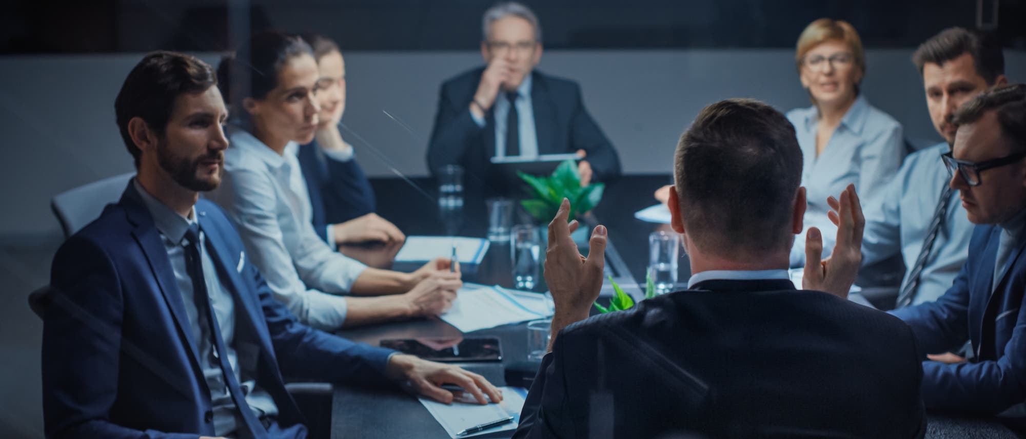 Eine Gruppe Geschäftsleute sitzt in einem Meeting zusammen