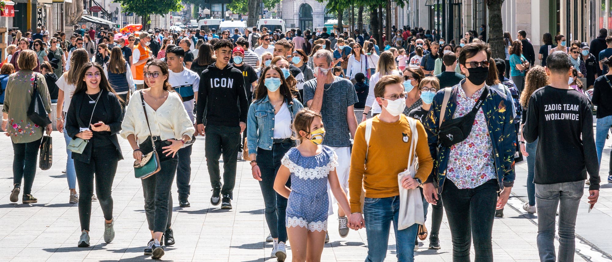 Eine Menschenmenge in einer Einkaufsstraße, zum Teil mit, zum Teil ohne Maske. Aufgenommen in Frankreich nach dem Ende des Lockdowns.
