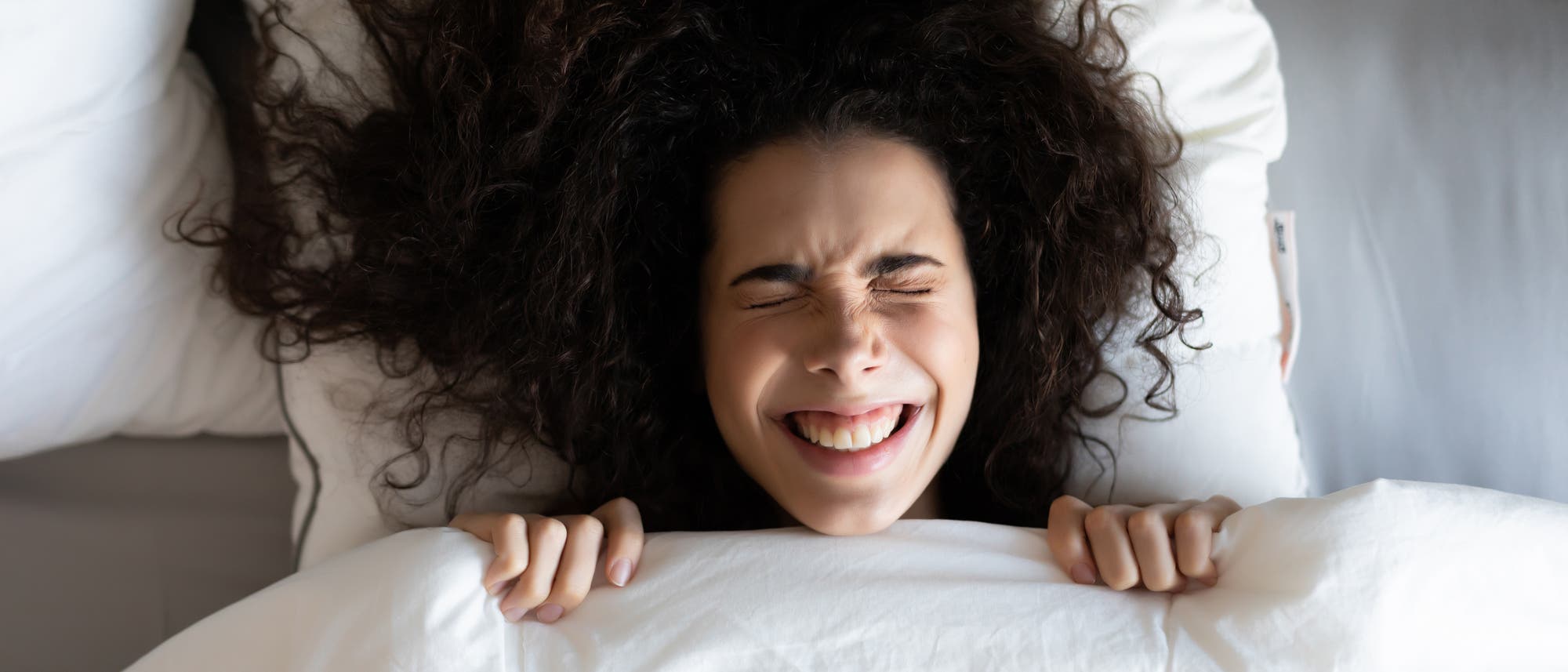 Eine lachende Frau im Bett