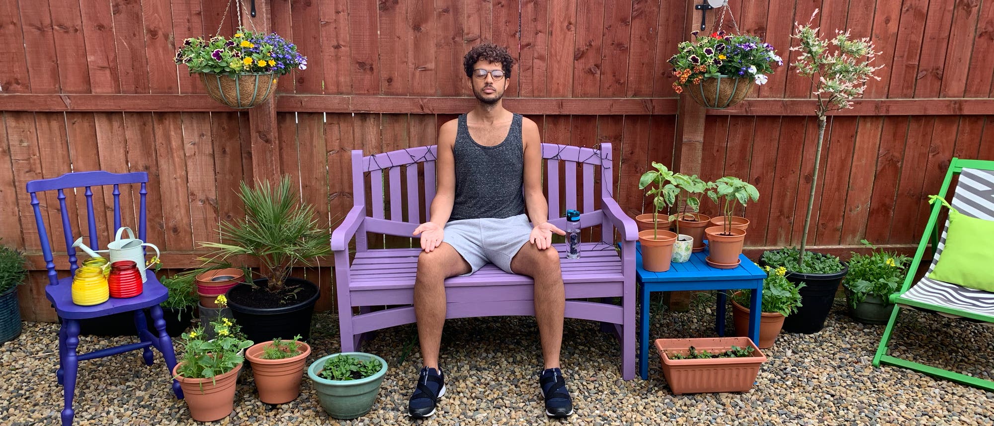 Ein Mann meditiert auf der Gartenbank im Hinterhof