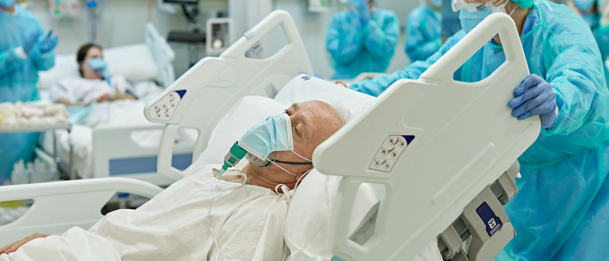 Beatmeter älterer Mann im Krankenbett wird von medizinischem Personal geschoben-