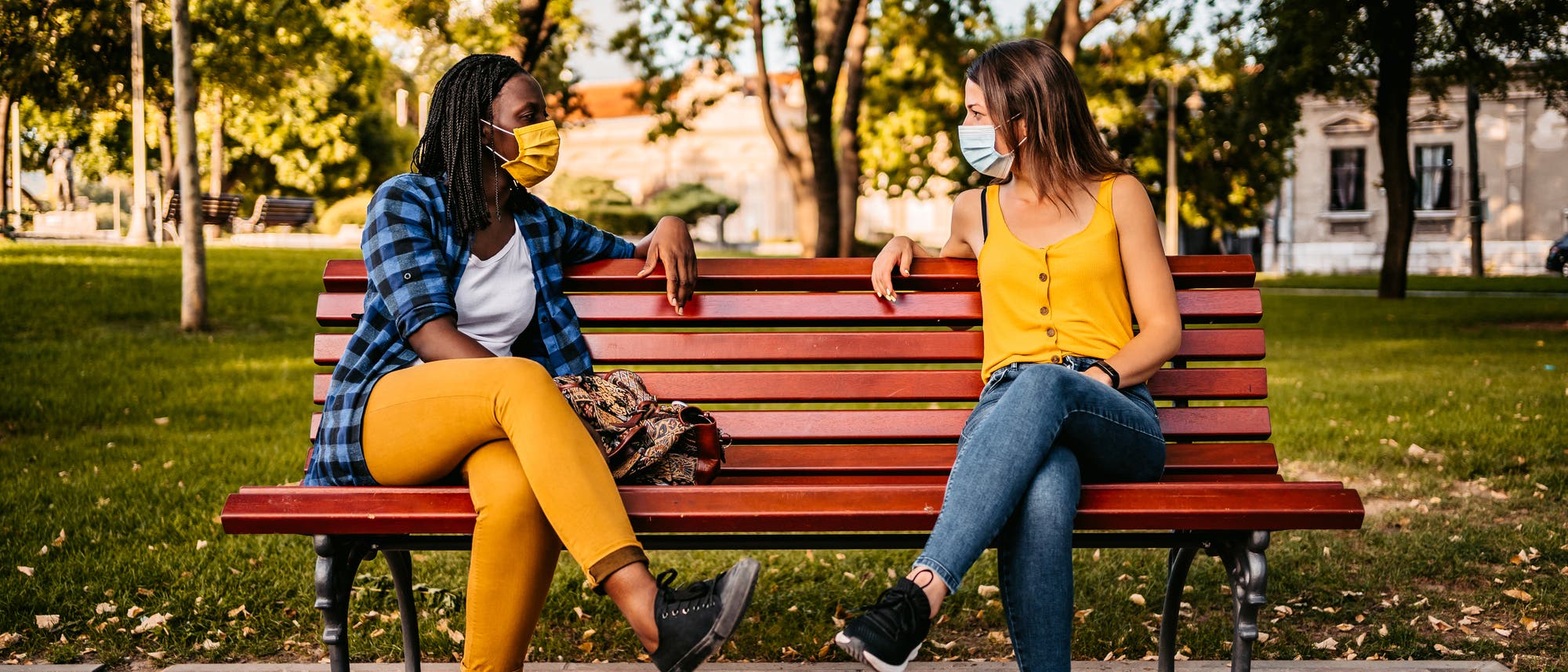 Zwei Frauen unterhalten sich auf einer Parkbank