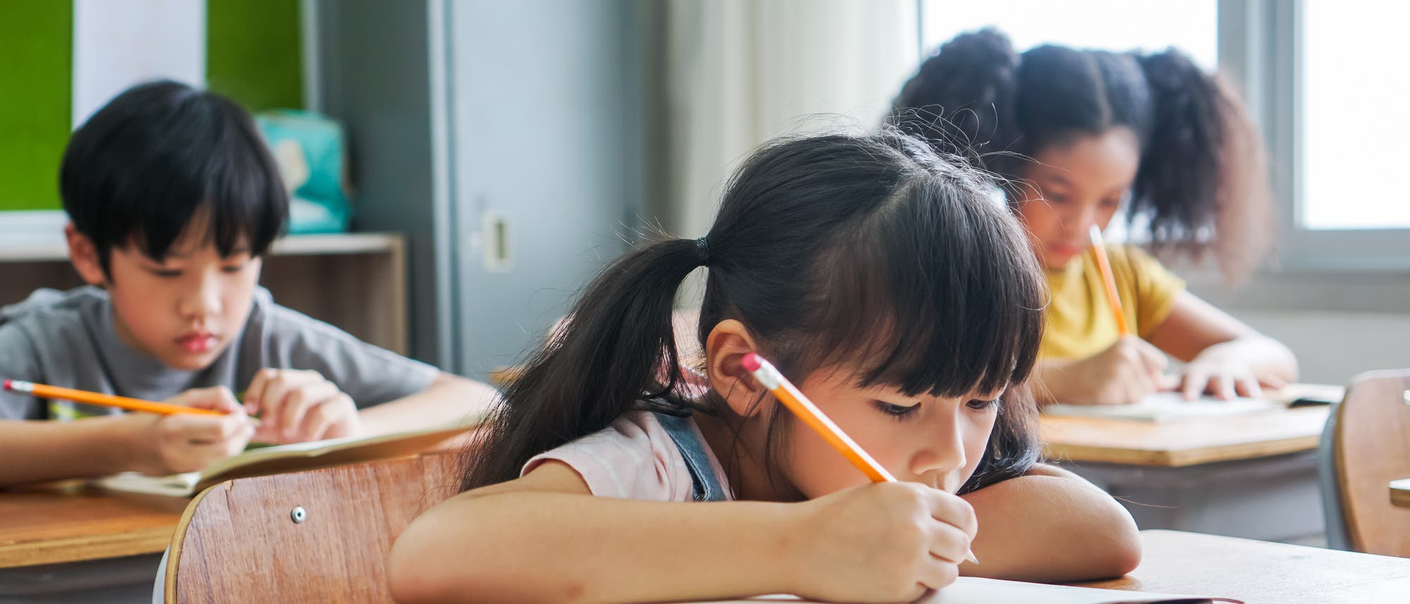 Kinder sitzen in einer Schulklasse in Asien