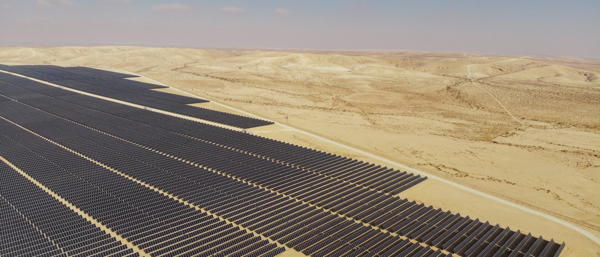 Eine große Anlage mit Photovoltaikpaneelen in der Wüste.