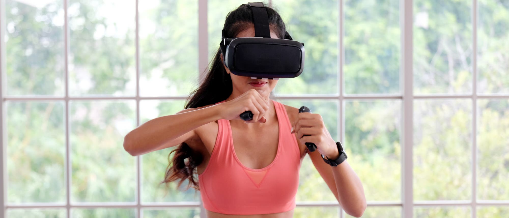 Junge Frau mit VR-Brille beim virtuellen Boxtraining