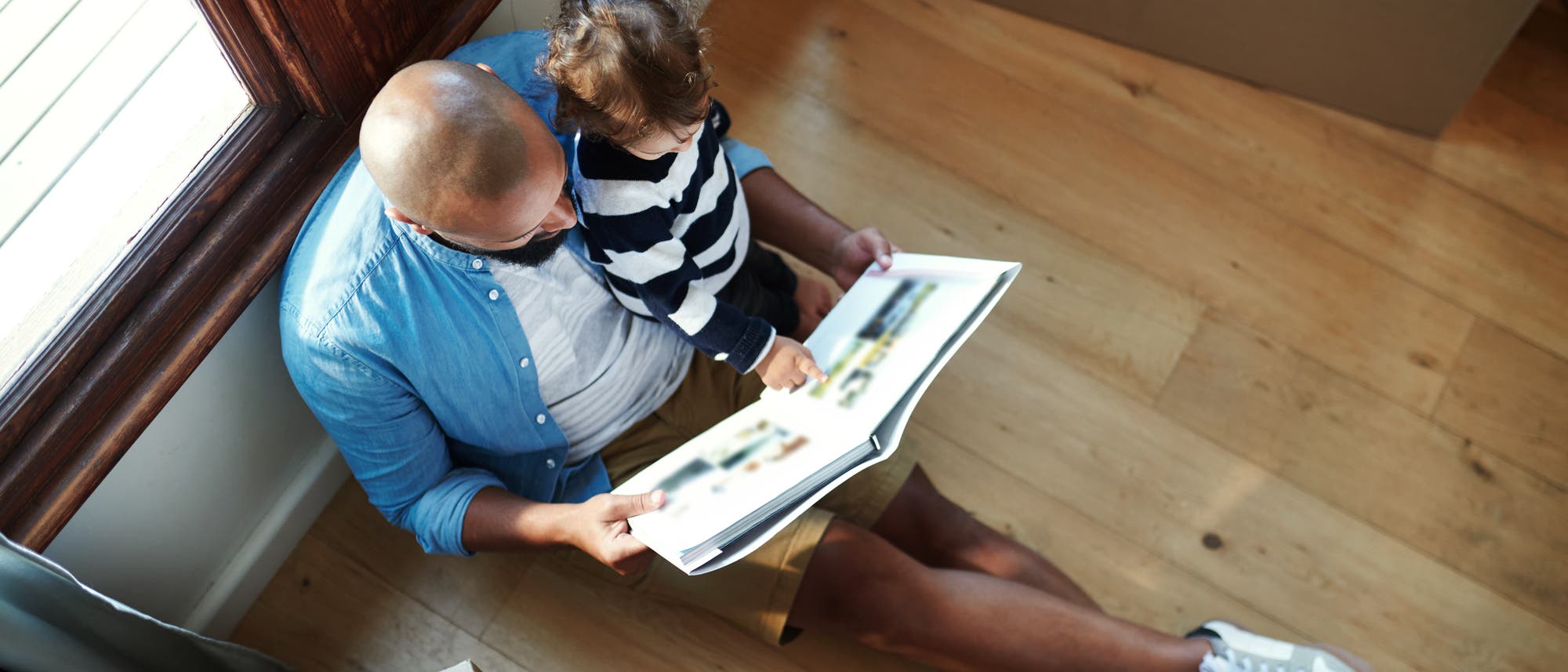 Vater betrachtet mit seinem Kind ein Buch