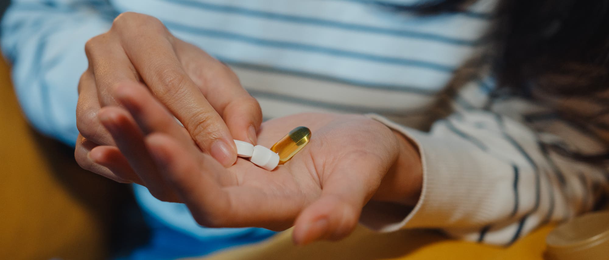 Eine Frau schüttet sich verschiedene Tabletten auf die Hand