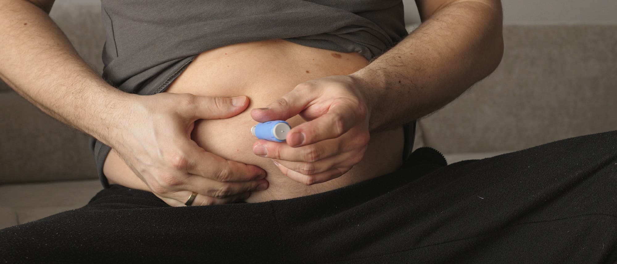 Ein Mann injiziert sich selbst den Wirkstoff Semaglutid mit einem Injektionspen in den Bauch.